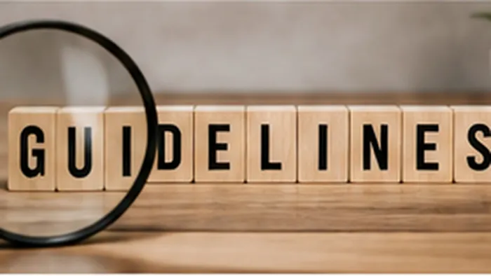 Title: Magnifying glass beside wooden blocks spelling guidelines. - Description: Magnifying glass beside wooden blocks spelling guidelines.